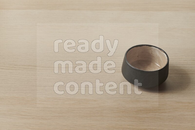 A multicolored pottery bowl on light wooden background