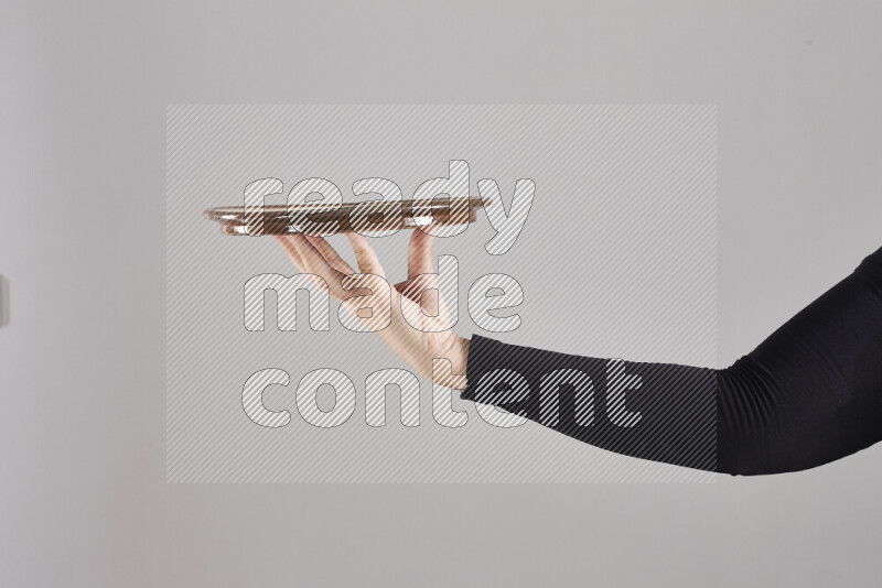 A woman in black abaya holding different pottery essentials in different positions