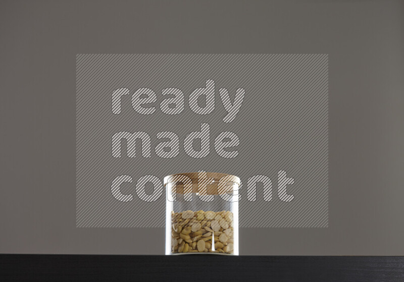 Crushed beans in a glass jar on black background