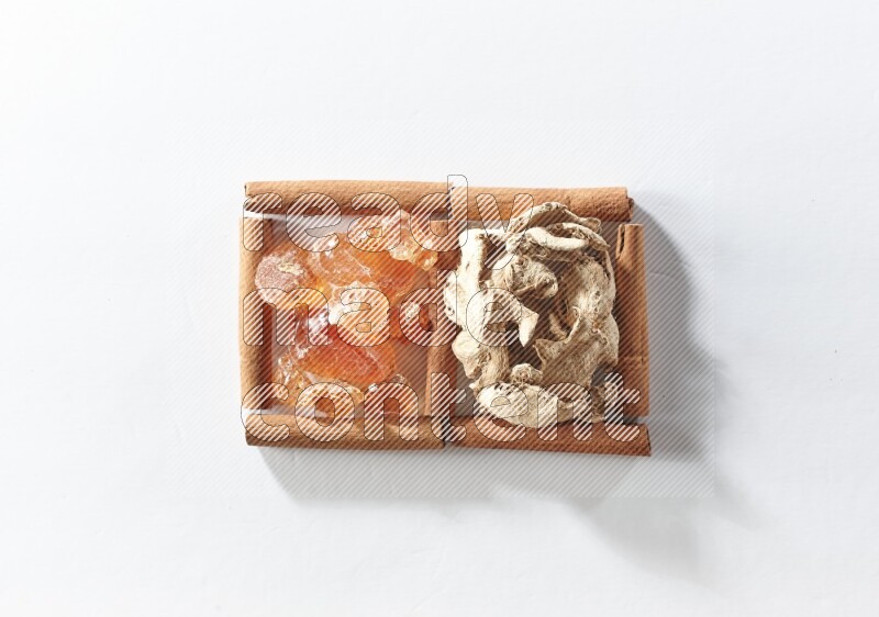2 squares of cinnamon sticks full of dried ginger and gum arabic on white flooring