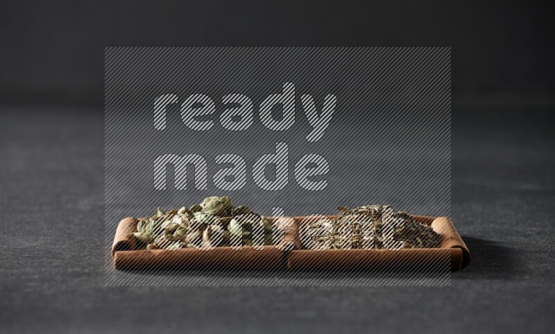 2 squares of cinnamon sticks full of cumin and cardamom on black flooring