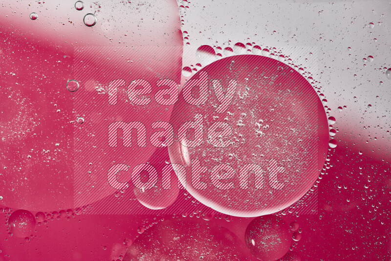 Close-ups of abstract oil bubbles on water surface in shades of white and pink