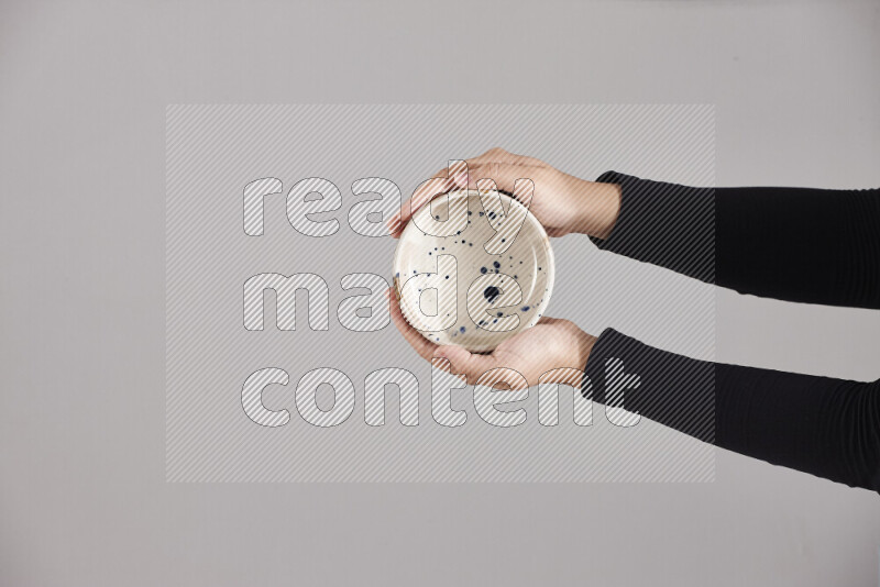A woman in black abaya holding different pottery essentials in different positions