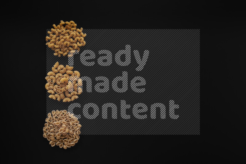 Different pasta types in 3 bunches on black background