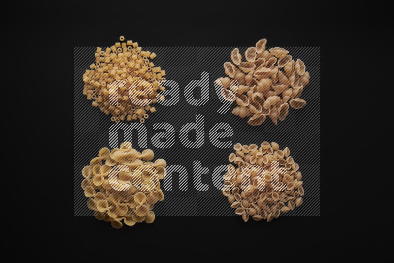 Different pasta types in bunches on black background
