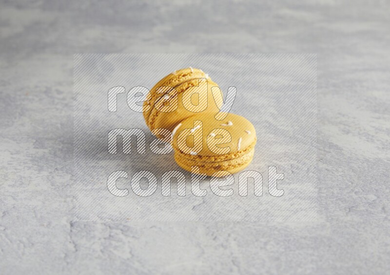45º Shot of two Yellow Piña Colada macarons  on white  marble background