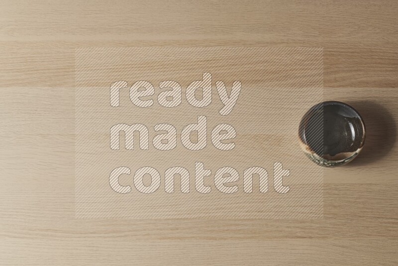 وعاء فخاري متعدد الألوان على خلفية خشبية فاتحة