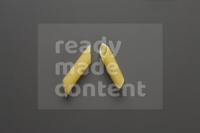 Penne pasta on grey background