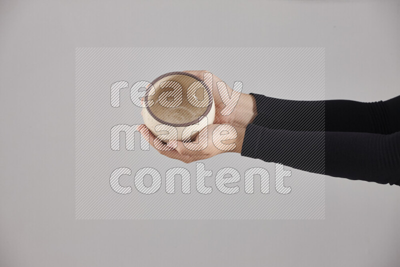 A woman in black abaya holding different pottery essentials in different positions