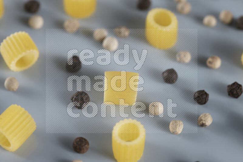 معكرونة مع مكونات متنوعة من الطماطم والثوم والبصل والفلفل الأحمر والفلفل الأسود والفلفل الأبيض وأوراق الغار وإكليل الجبل والهيل و مشروم على خلفية زرقاء فاتحة