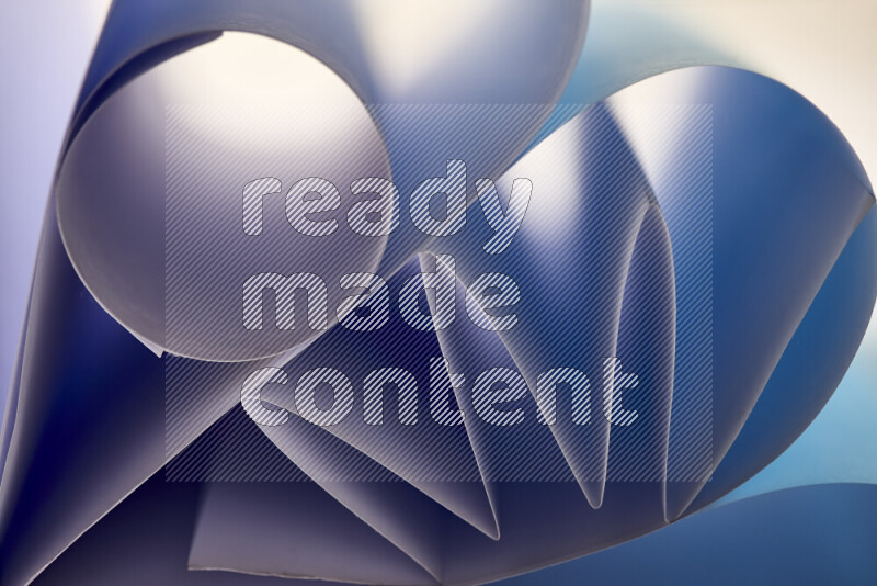 An artistic display of paper folds creating a harmonious blend of geometric shapes, highlighted by soft lighting in blue tones