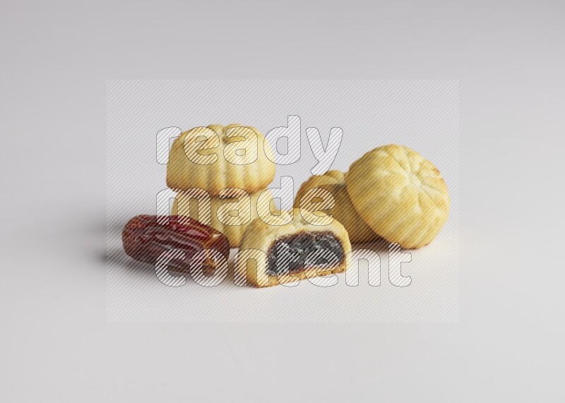 Five Pieces of Maamoul filled with date one of them is cut direct on white background