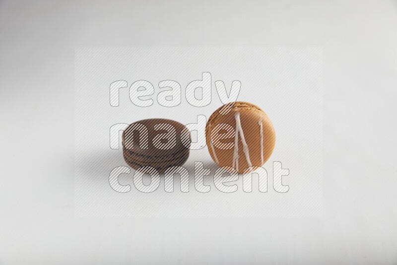45º Shot of of two assorted Brown Irish Cream, and Brown Dark Chocolate macarons on white background