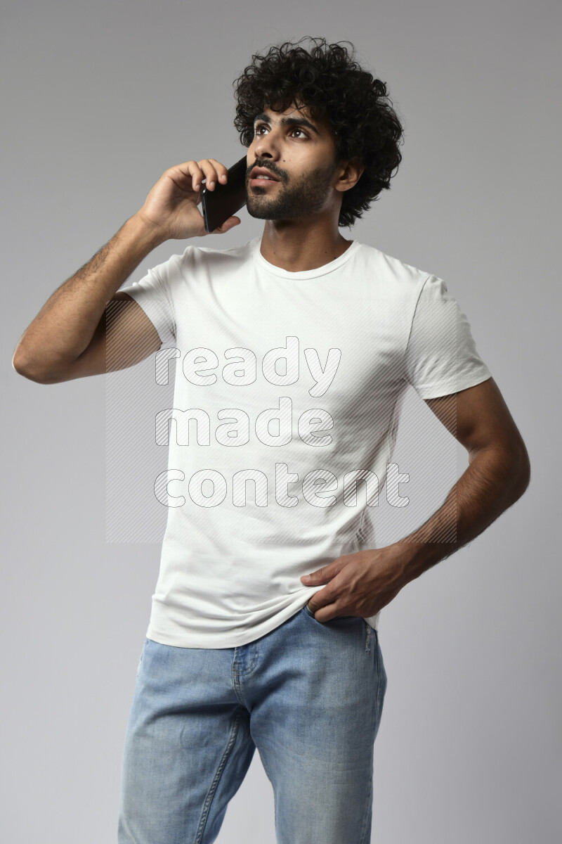 A man wearing casual standing and talking on the phone on white background