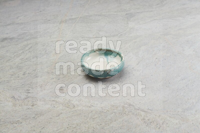 A multicolored pottery bowl on grey marble background