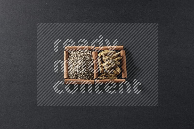 2 squares of cinnamon sticks full of white pepper and turmeric fingers on black flooring