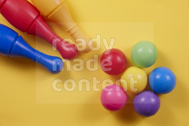 Plastic bowling pins with balls on different colored backgrounds (kids toys)