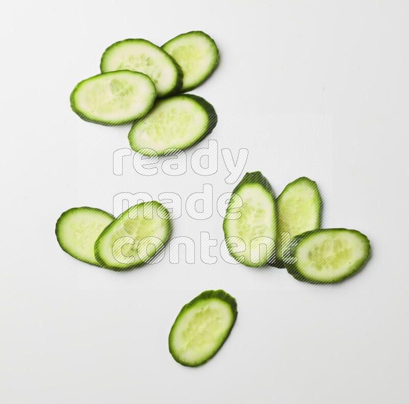 Multiple cucumber slices on white background