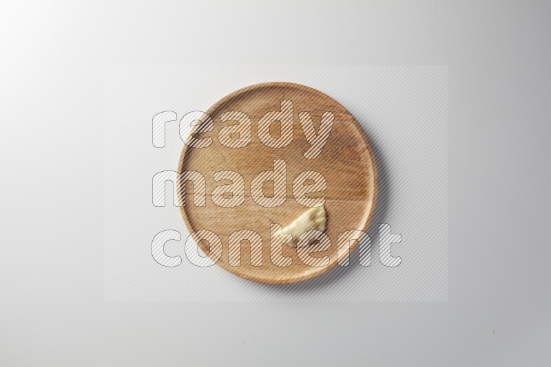 A single Sambosa on a wooden round plate on a white background