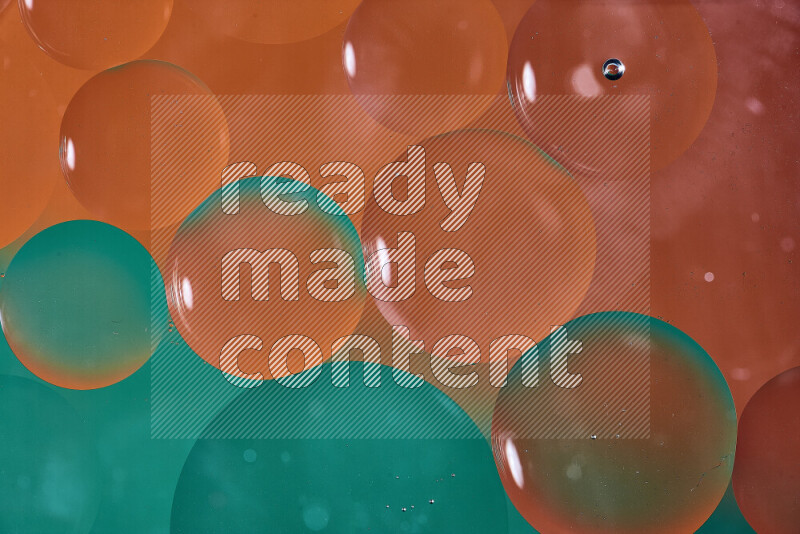 Close-ups of abstract oil bubbles on water surface in shades of green and orange