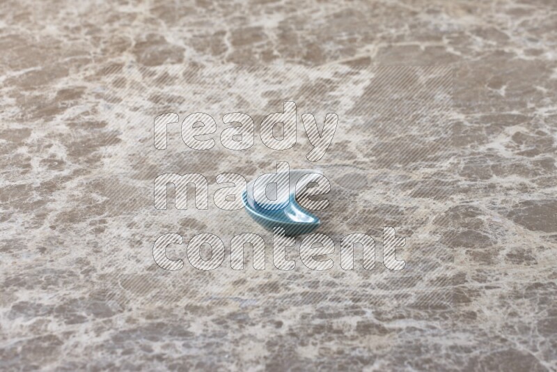 صحن فخاري على شكل هلال على خلفية من الرخام باللون البيج