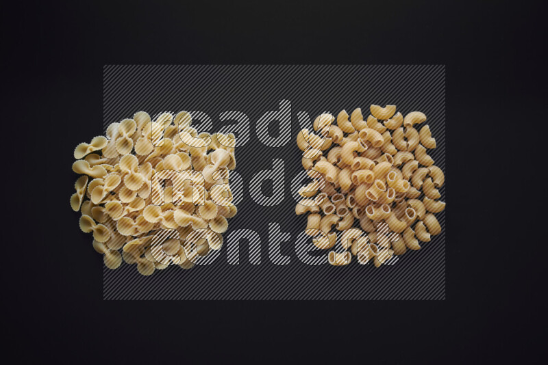 Different pasta types in bunches on black background