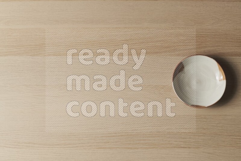 صحن فخاري متعدد الألوان على خلفية خشبية فاتحة