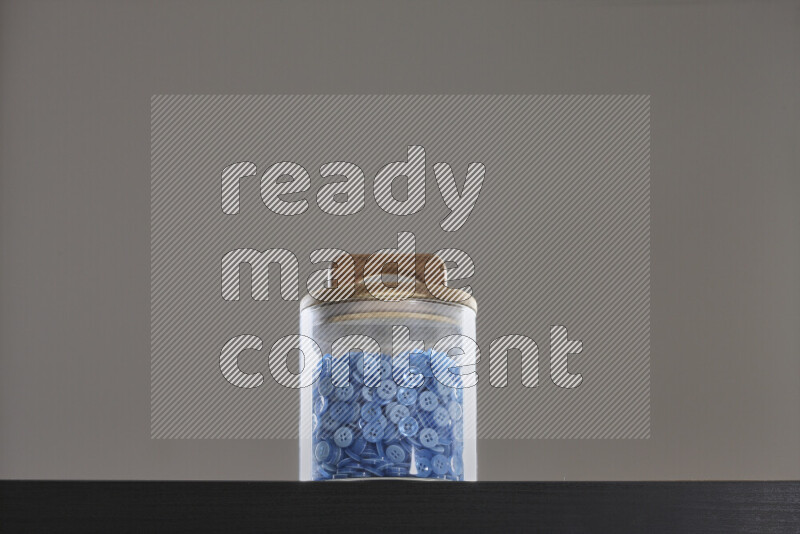 Buttons in a glass jar on black background