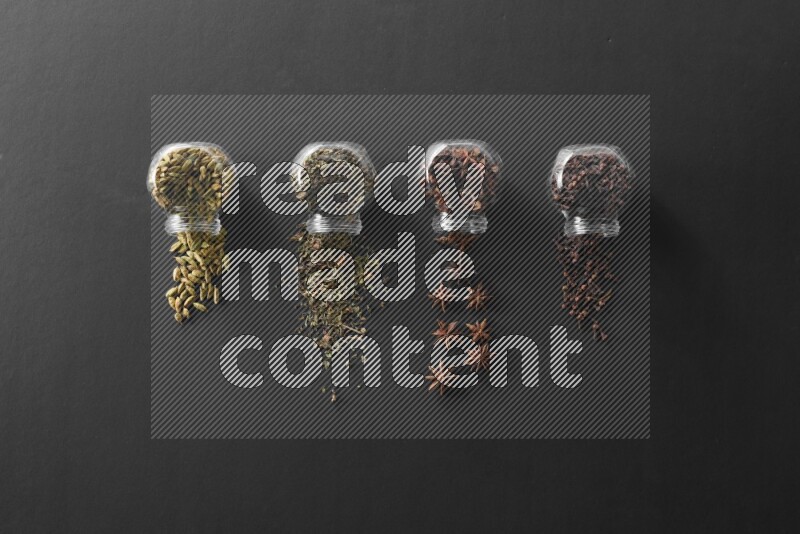 قرنفل وحبوب الهيل وريحان مجفف ويانسون نجمي في أوعية زجاجية علي خلفية سوداء