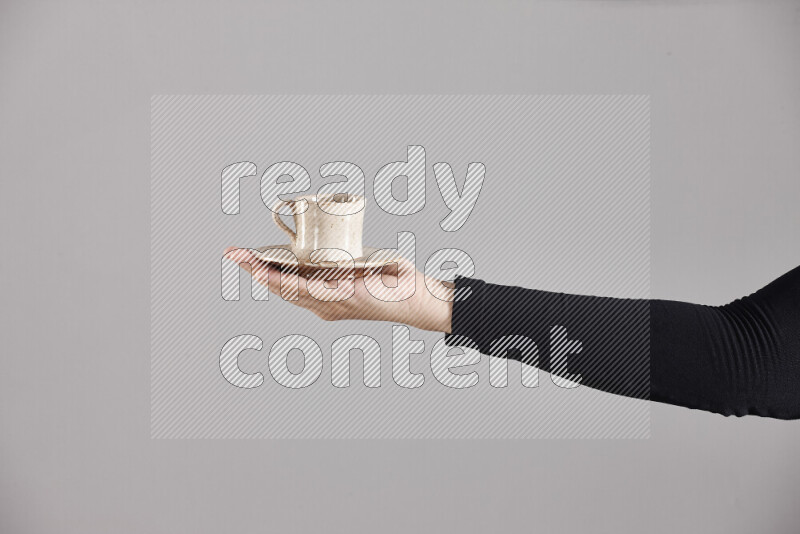 A woman in black abaya holding different pottery essentials in different positions