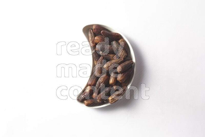 Dates in a crescent pottery plate on white background