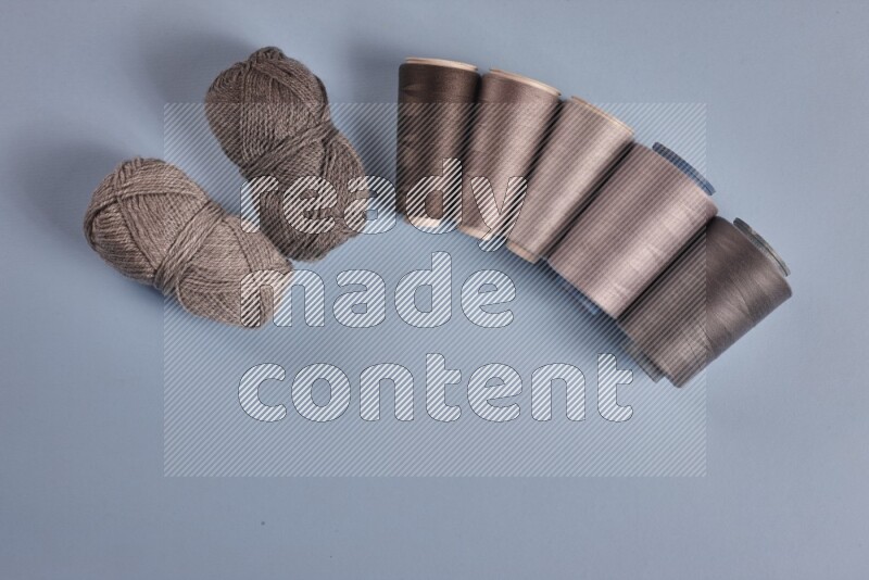 A grey collection of sewing and tailoring tools arranged on a blue background