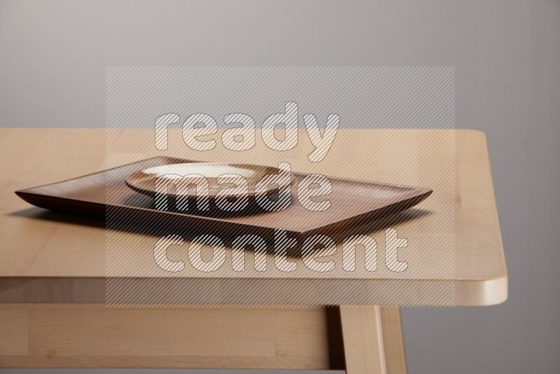 multicolored plate on a rectangular wooden tray on the edge of wooden table