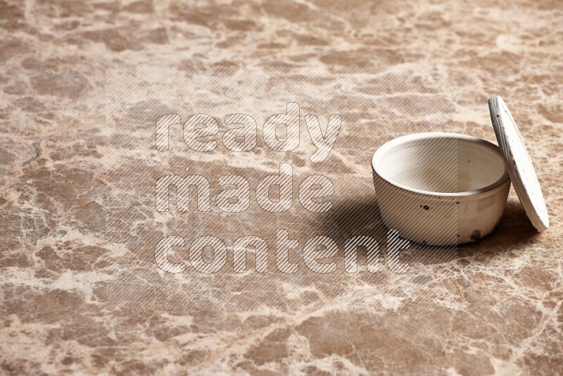 A white pottery bowl on beige marble background