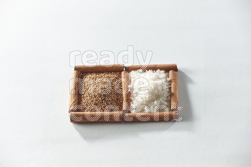 2 squares of cinnamon sticks full of mustard seeds and white salt on white flooring