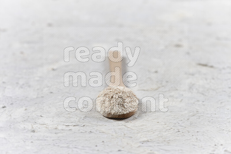 A wooden spoon full of onion powder on white background