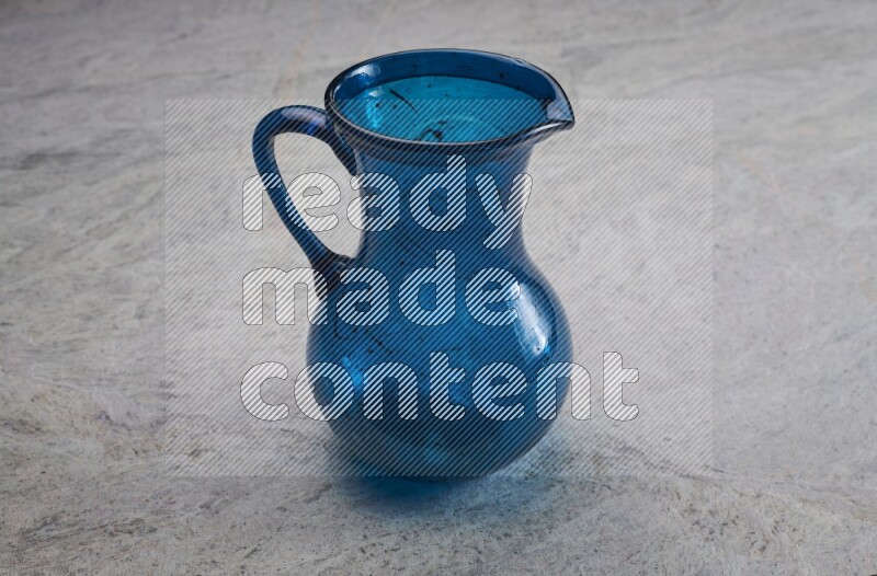 A colored glass jug on grey marble background