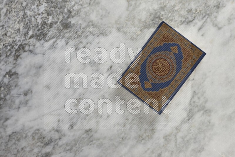 Quran with a prayer beads on grey marble background