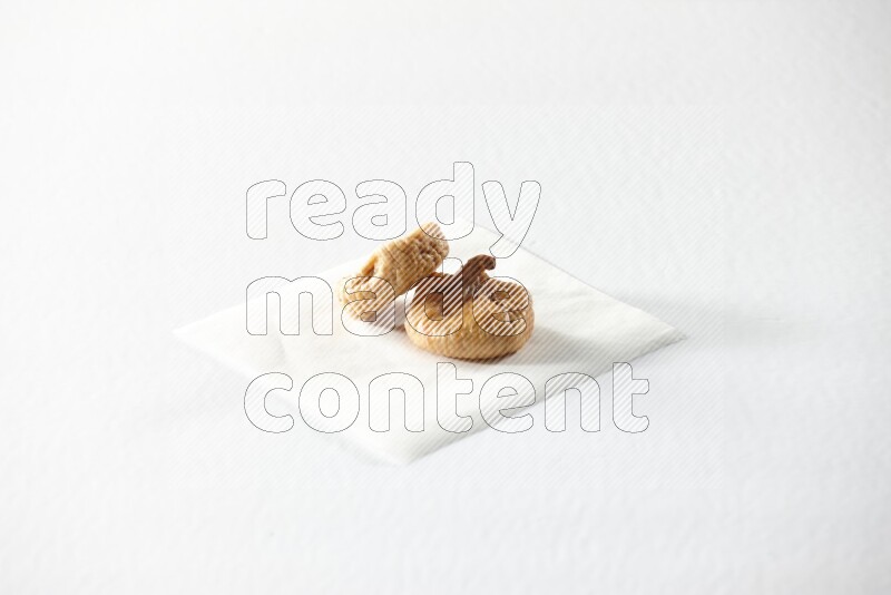 Two dried figs on a piece of paper on a white background in different angles
