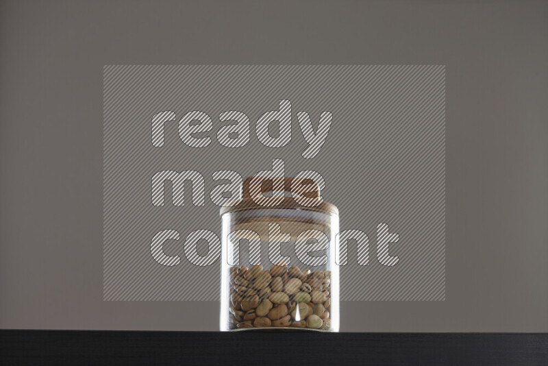 Fava beans in a glass jar on black background