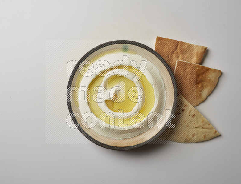 Lebnah garnished with olive oil in a pottery plate on a white background