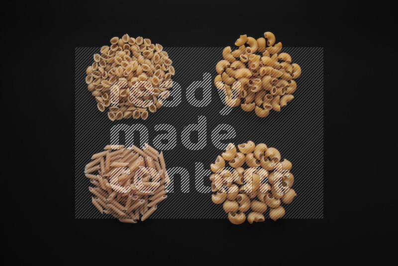 Different pasta types in bunches on black background