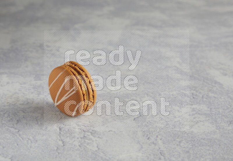 45º Shot of Brown Irish Cream macaron on white marble background