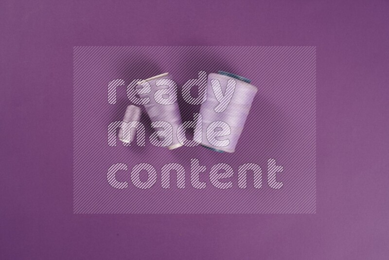 A purple collection of sewing and tailoring tools arranged on a purple background