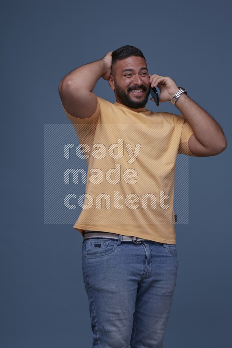 A man Calling on Blue Background wearing Orange T-shirt