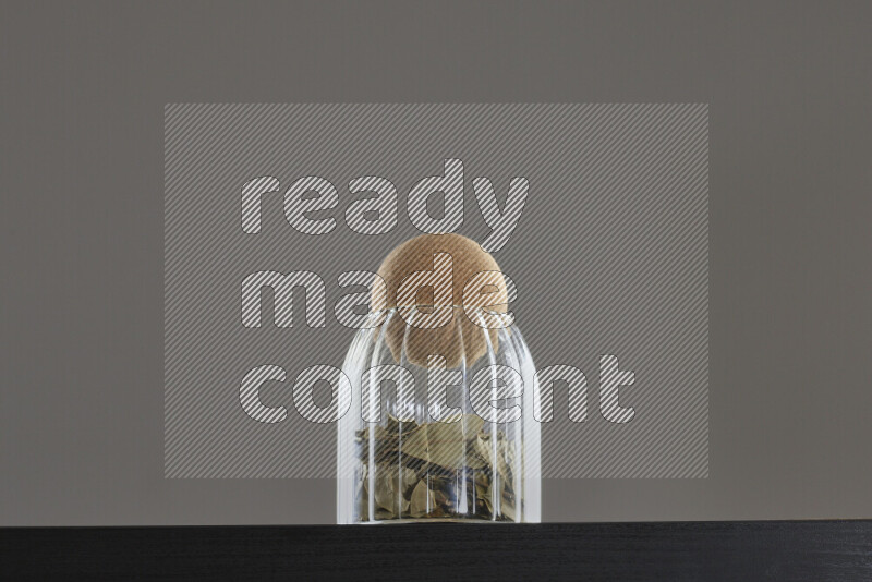 Bay laurel leaves in a glass jar on black background