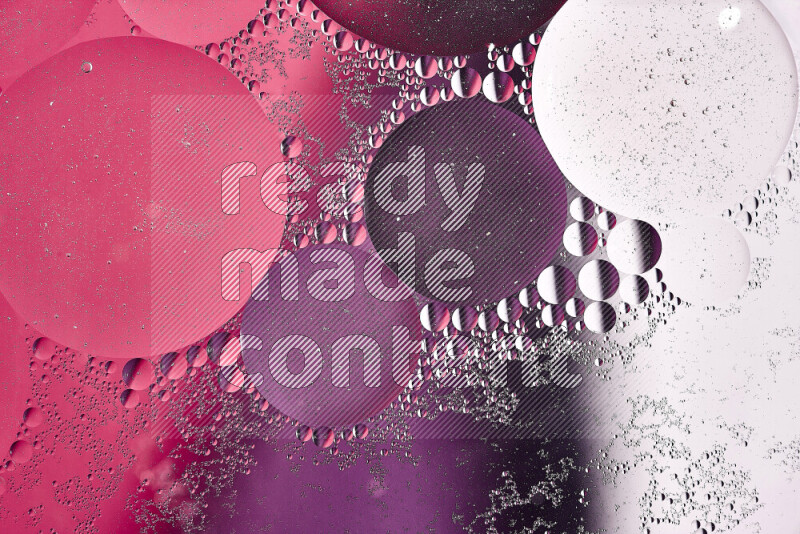 Close-ups of abstract oil bubbles on water surface in shades of white, purple and pink