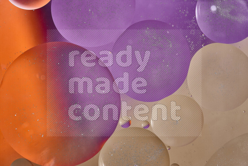 Close-ups of abstract oil bubbles on water surface in shades of brown, orange and purple