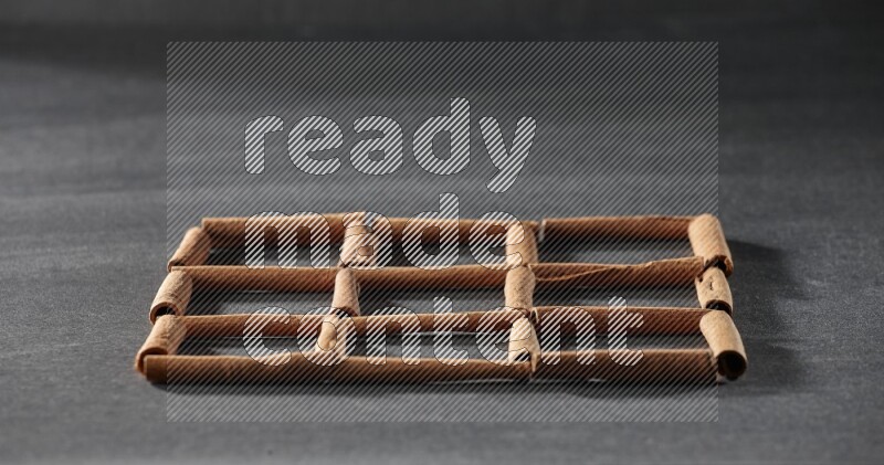 9 empty squares of cinnamon sticks on black flooring