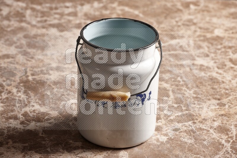 A vintage milk can on beige marble background